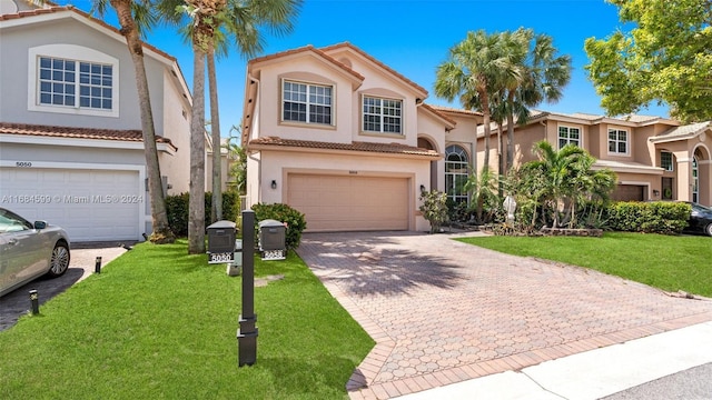 mediterranean / spanish home featuring a garage and a front lawn