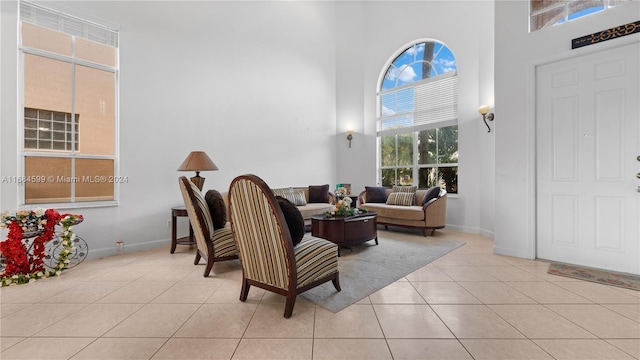 living room featuring plenty of natural light, light tile patterned flooring, and a high ceiling