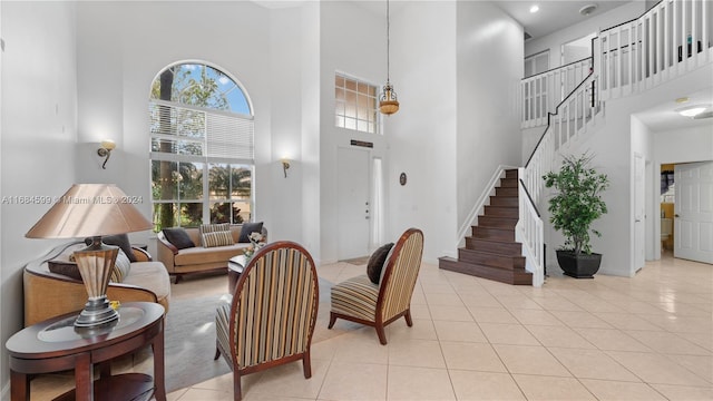 living room with a towering ceiling and light tile patterned flooring