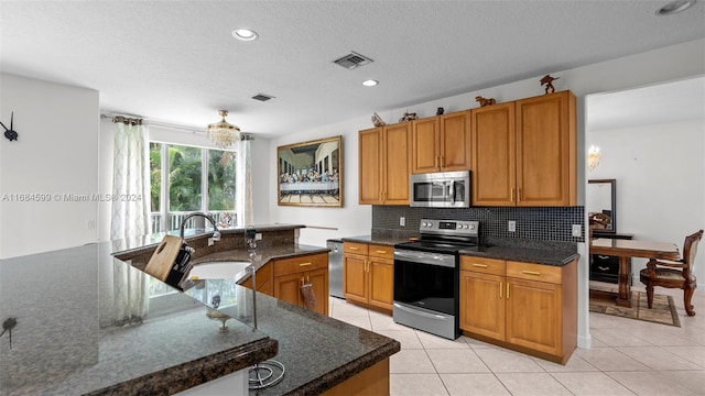 kitchen featuring dark stone countertops, sink, a kitchen island, and stainless steel appliances