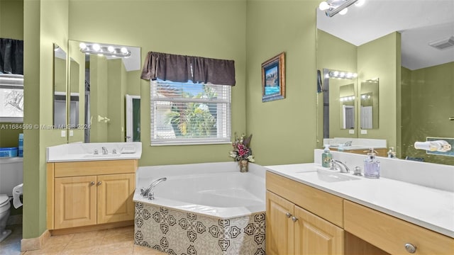 bathroom featuring vanity, tile patterned flooring, a relaxing tiled tub, and toilet