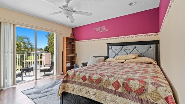 bedroom featuring ceiling fan, hardwood / wood-style floors, a textured ceiling, access to outside, and a water view