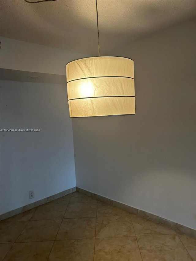 tiled empty room with a textured ceiling