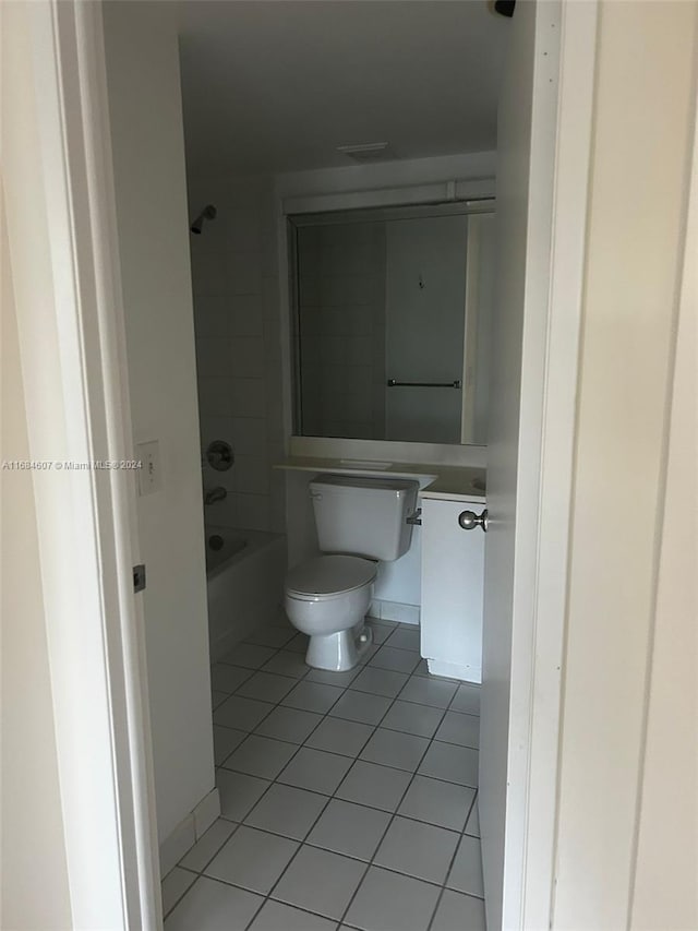 bathroom featuring tile patterned flooring, toilet, and shower / bathtub combination