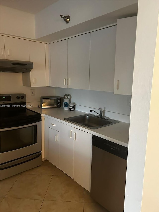 kitchen featuring light tile patterned floors, white cabinetry, sink, and appliances with stainless steel finishes