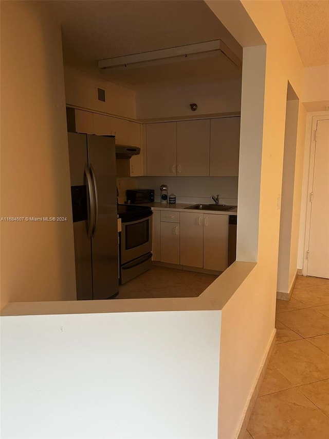 kitchen featuring sink, light tile patterned floors, and stainless steel appliances