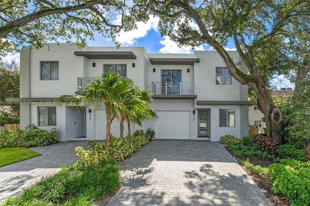 view of front of property featuring a garage and a balcony