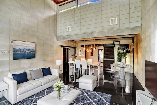 living room featuring a notable chandelier and a towering ceiling