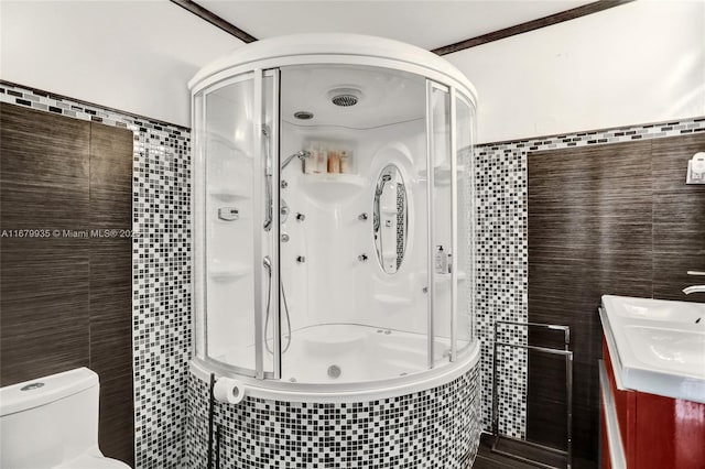 bathroom featuring crown molding, a shower with door, tile walls, and toilet