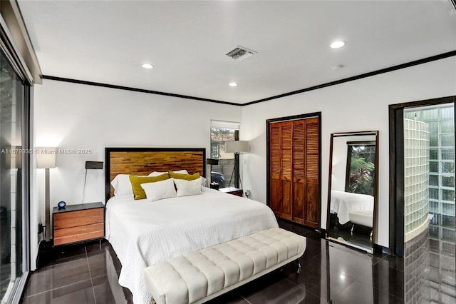 bedroom with dark tile patterned floors, a closet, and crown molding