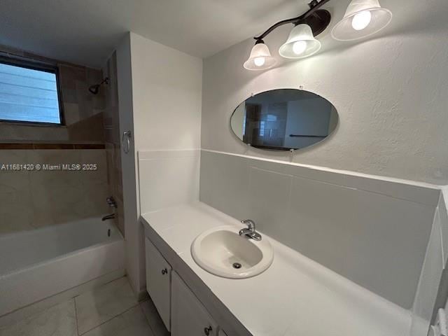 bathroom with tiled shower / bath combo, tile patterned flooring, and vanity