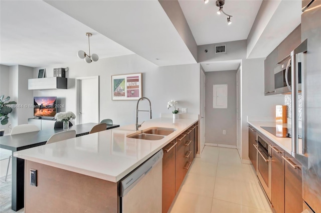 kitchen featuring sink, an island with sink, stainless steel appliances, and light tile patterned flooring