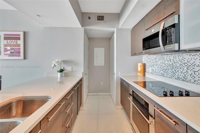 kitchen featuring decorative backsplash, stainless steel appliances, sink, and light tile patterned floors