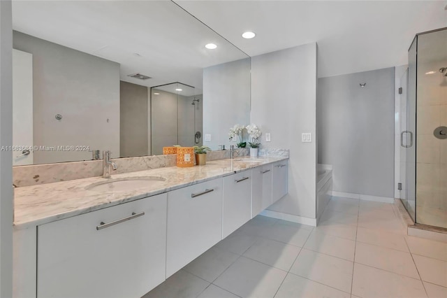 bathroom featuring vanity, independent shower and bath, and tile patterned floors