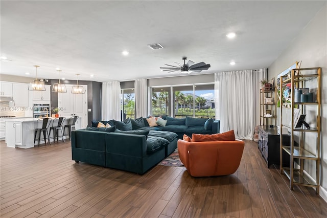 living room featuring ceiling fan and dark hardwood / wood-style flooring