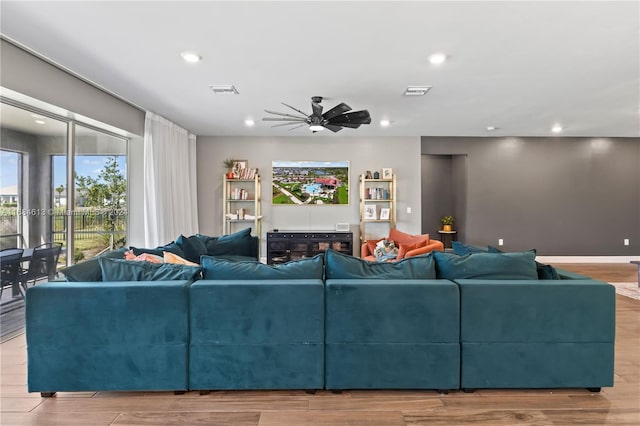 living room with ceiling fan and light hardwood / wood-style flooring