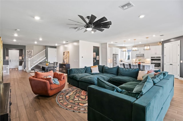 living room with ceiling fan and light wood-type flooring