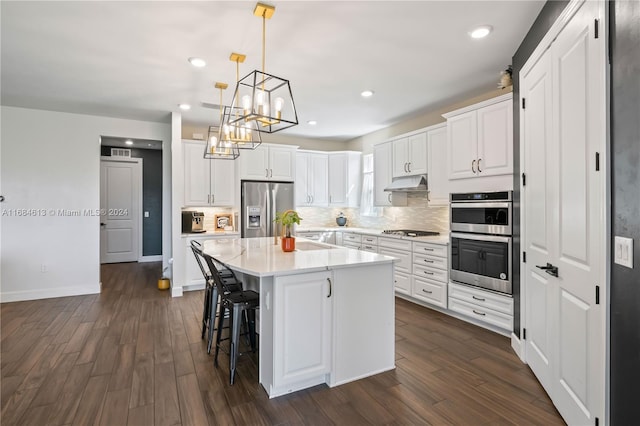 kitchen featuring white cabinets, dark wood-type flooring, appliances with stainless steel finishes, and a center island