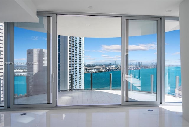 spare room featuring a water view and a wall of windows