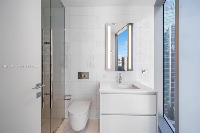 bathroom with vanity, toilet, tile walls, and a shower with door