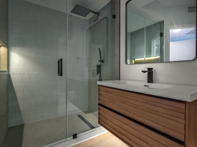 bathroom with vanity, a stall shower, and visible vents