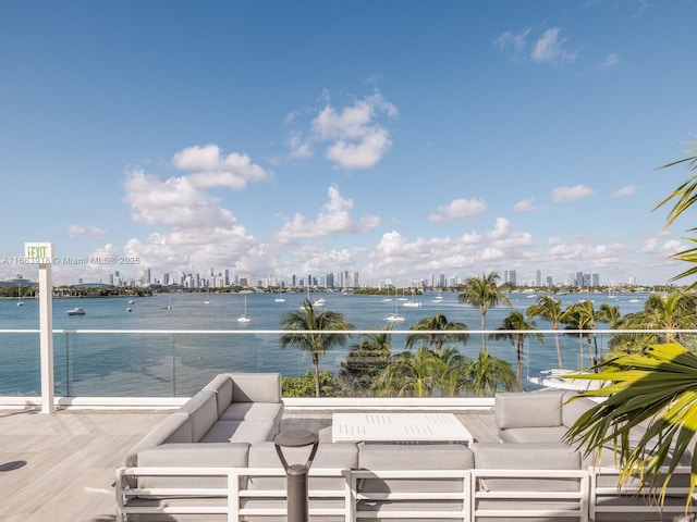 view of patio / terrace with a water view, a balcony, and a city view