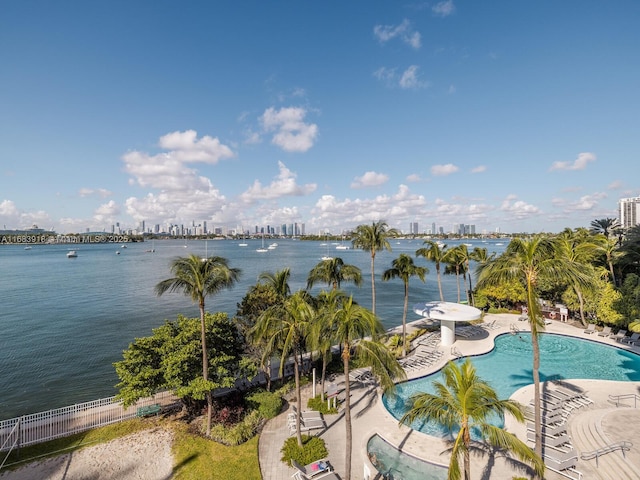 community pool with a city view, a water view, and a patio