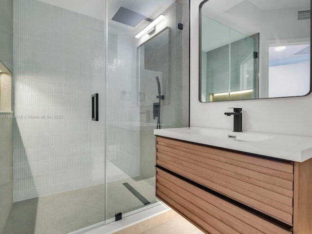 bathroom featuring visible vents, vanity, and a stall shower