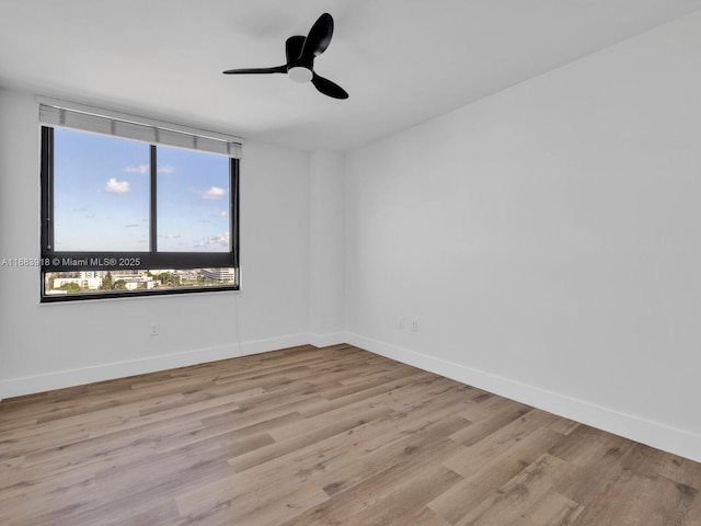 empty room with light wood-style flooring, baseboards, and a ceiling fan