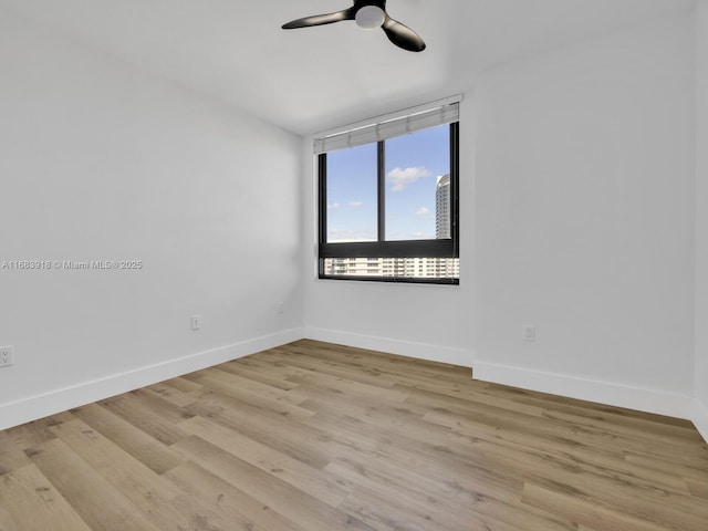 empty room featuring ceiling fan, baseboards, and light wood finished floors