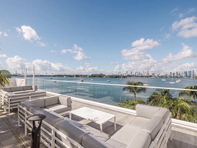 view of patio with an outdoor living space, a view of city, and a water view