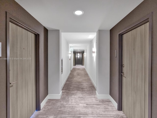hallway featuring wood finished floors, baseboards, and recessed lighting