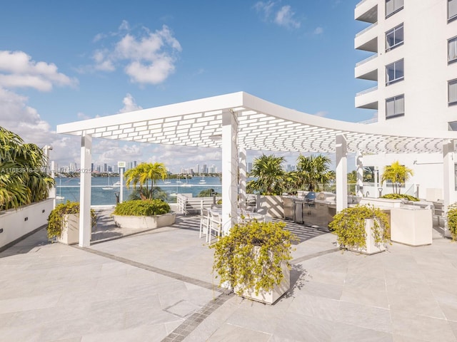 view of patio featuring a city view, a water view, and a pergola