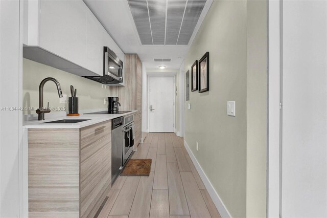 kitchen featuring white cabinetry, sink, and stainless steel appliances