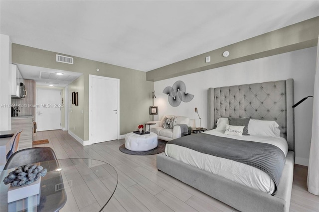 bedroom with sink and light hardwood / wood-style flooring