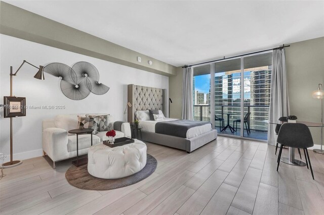 bedroom with floor to ceiling windows and access to exterior