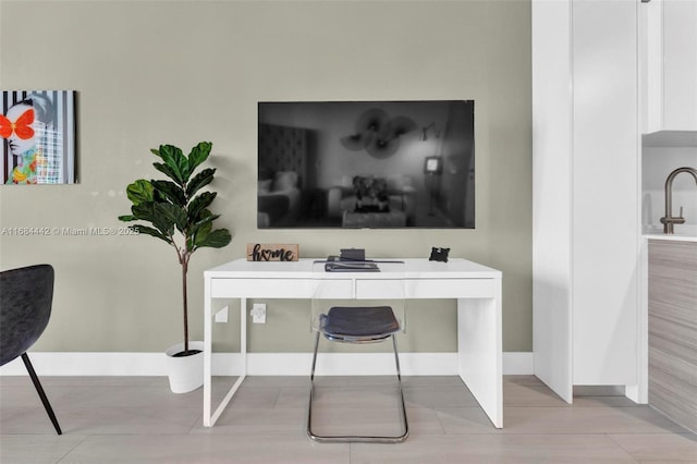 office area with light tile patterned floors and sink