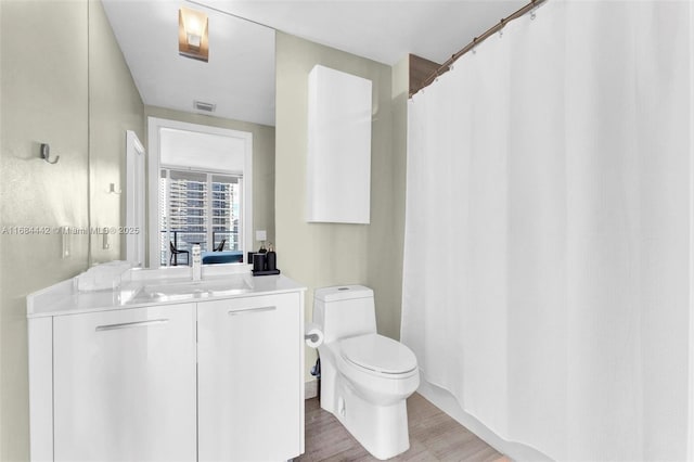 bathroom featuring hardwood / wood-style flooring, vanity, and toilet