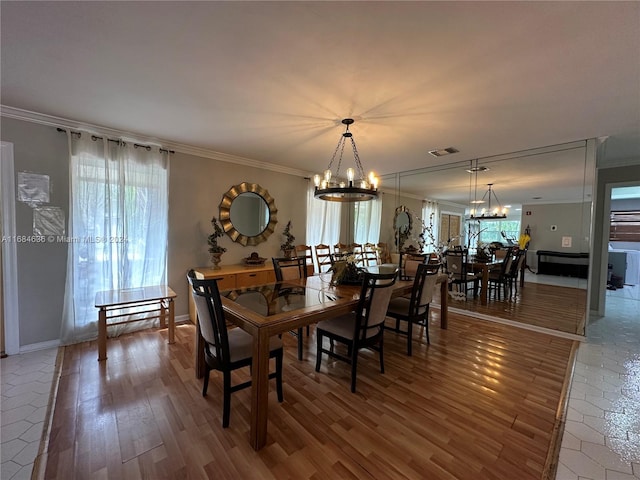 dining space featuring crown molding, a healthy amount of sunlight, wood-type flooring, and a chandelier