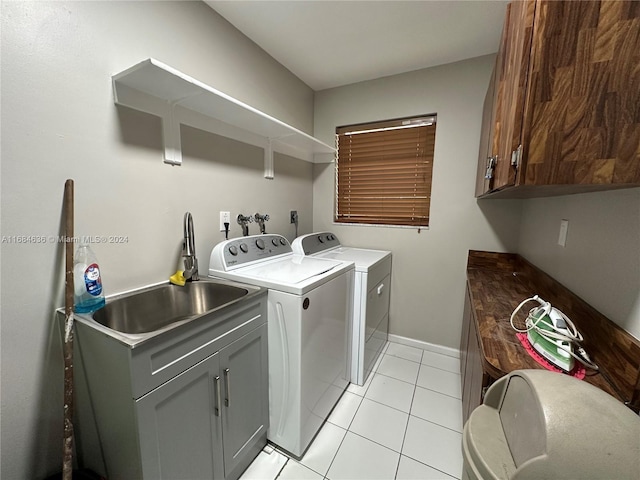 laundry room featuring sink, washing machine and dryer, light tile patterned floors, and cabinets