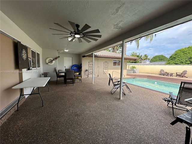 view of patio featuring ceiling fan and a fenced in pool