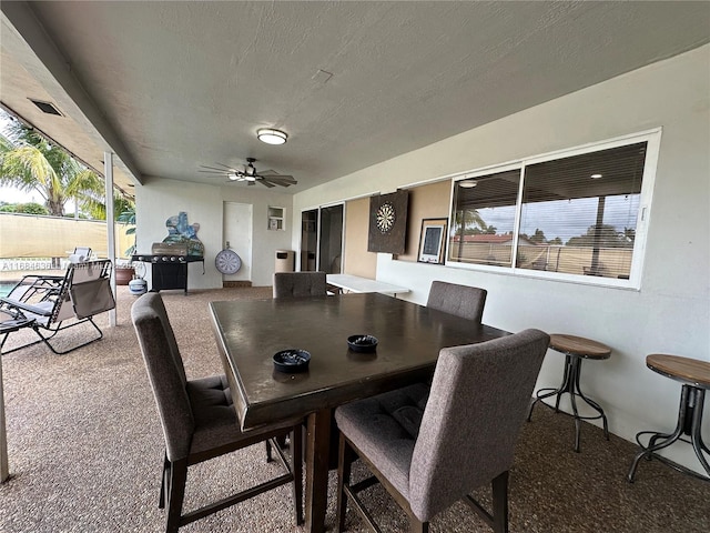 dining space featuring a textured ceiling, carpet flooring, and a wealth of natural light