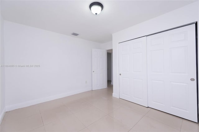 unfurnished bedroom with a closet and light tile patterned floors