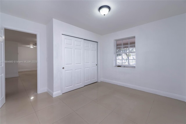 unfurnished bedroom featuring light tile patterned flooring and a closet