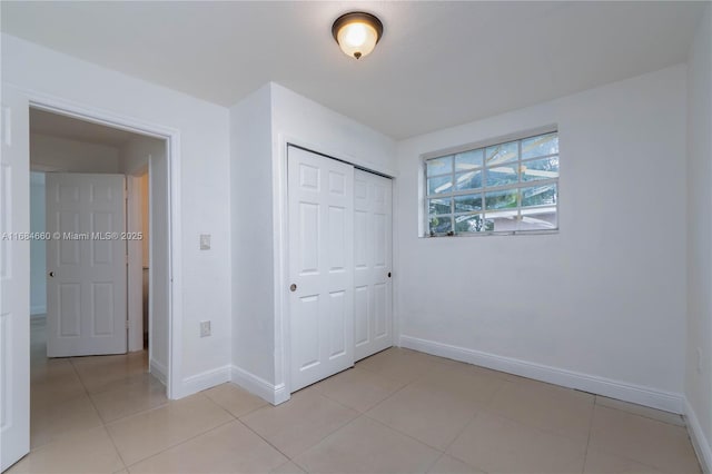 unfurnished bedroom with a closet and light tile patterned floors