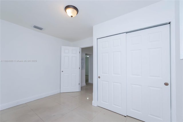 unfurnished bedroom featuring a closet and light tile patterned floors