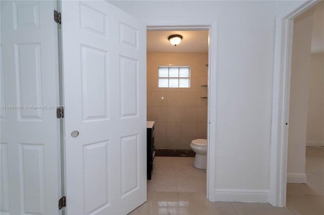 bathroom featuring vanity, tile walls, tile patterned floors, and toilet