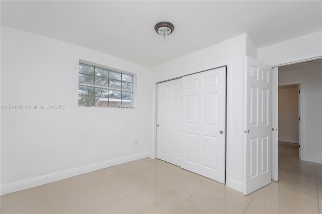 unfurnished bedroom featuring a closet and light tile patterned floors