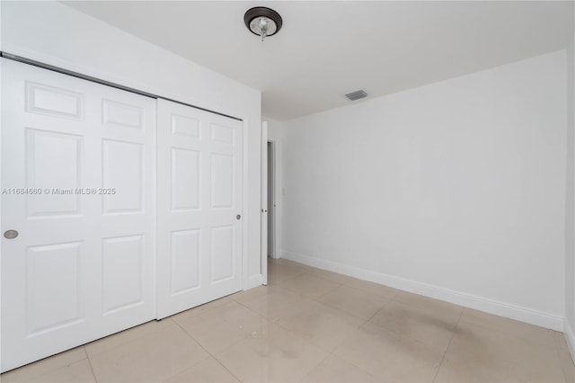 unfurnished bedroom featuring light tile patterned flooring and a closet