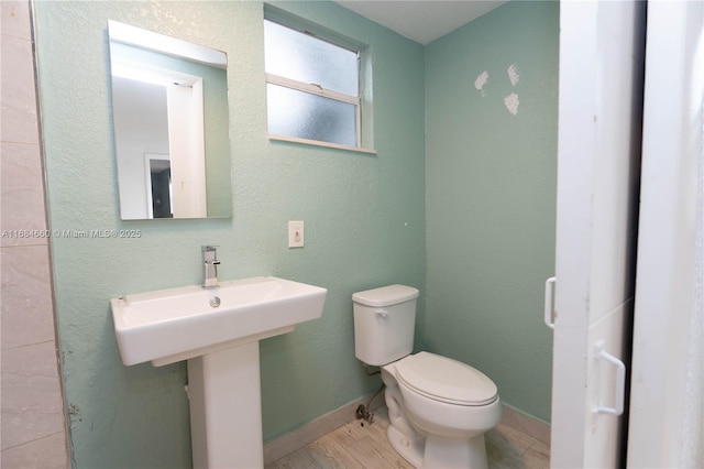 bathroom with hardwood / wood-style flooring and toilet